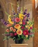 Peach roses,purple larkspur,pretty gerbers,sweet heart roses ec. make this a beautiful mixed arrangementt